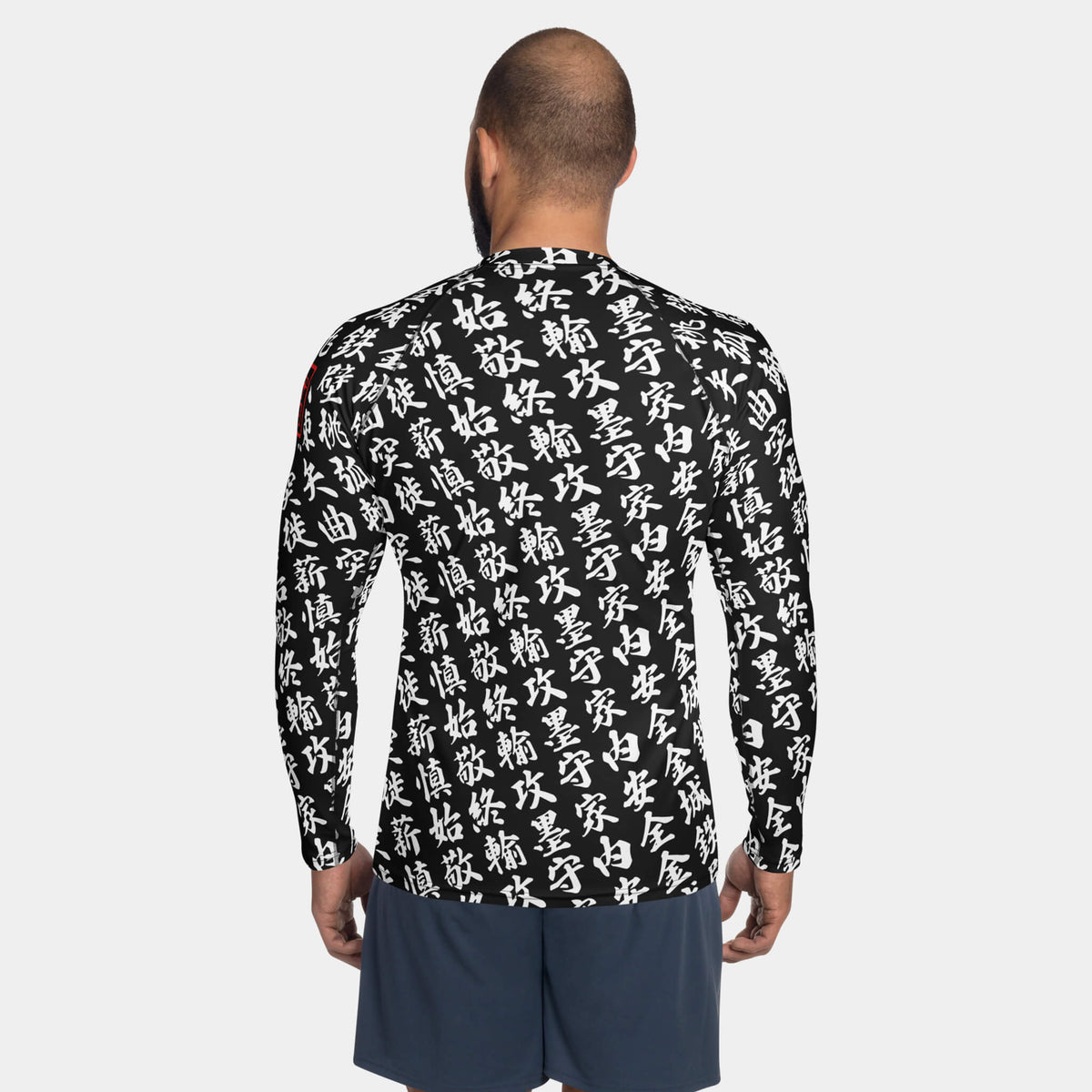 Back view of the men's TOO MUCH KANJI long-sleeve BJJ rash guard in Iron Black and White on a model