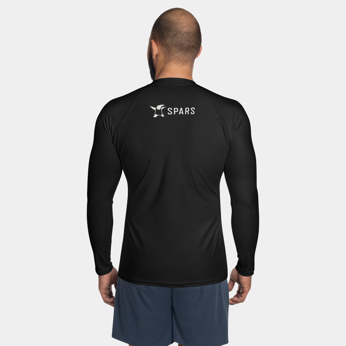Man wearing the Men’s BJJ KATAKANA Long-Sleeve Rash Guard in Iron Black, back view with off-white SPARS upper-back logo