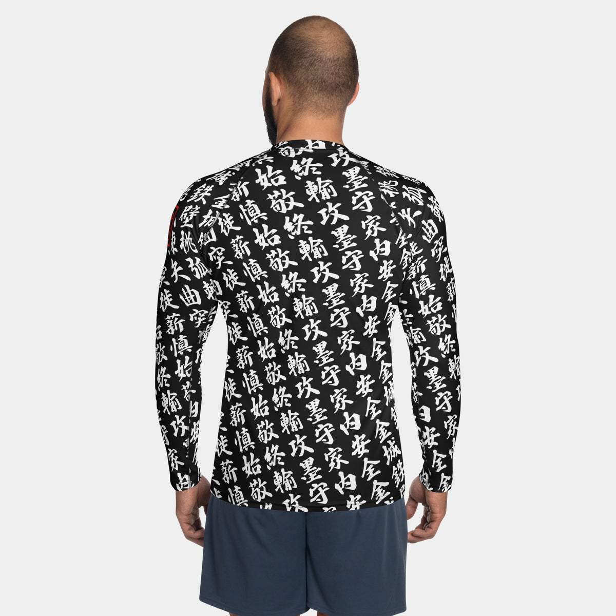 Back view of the TOO MUCH KANJI long-sleeve BJJ rash guard in Iron Black and White, showing the all-over white kanji print