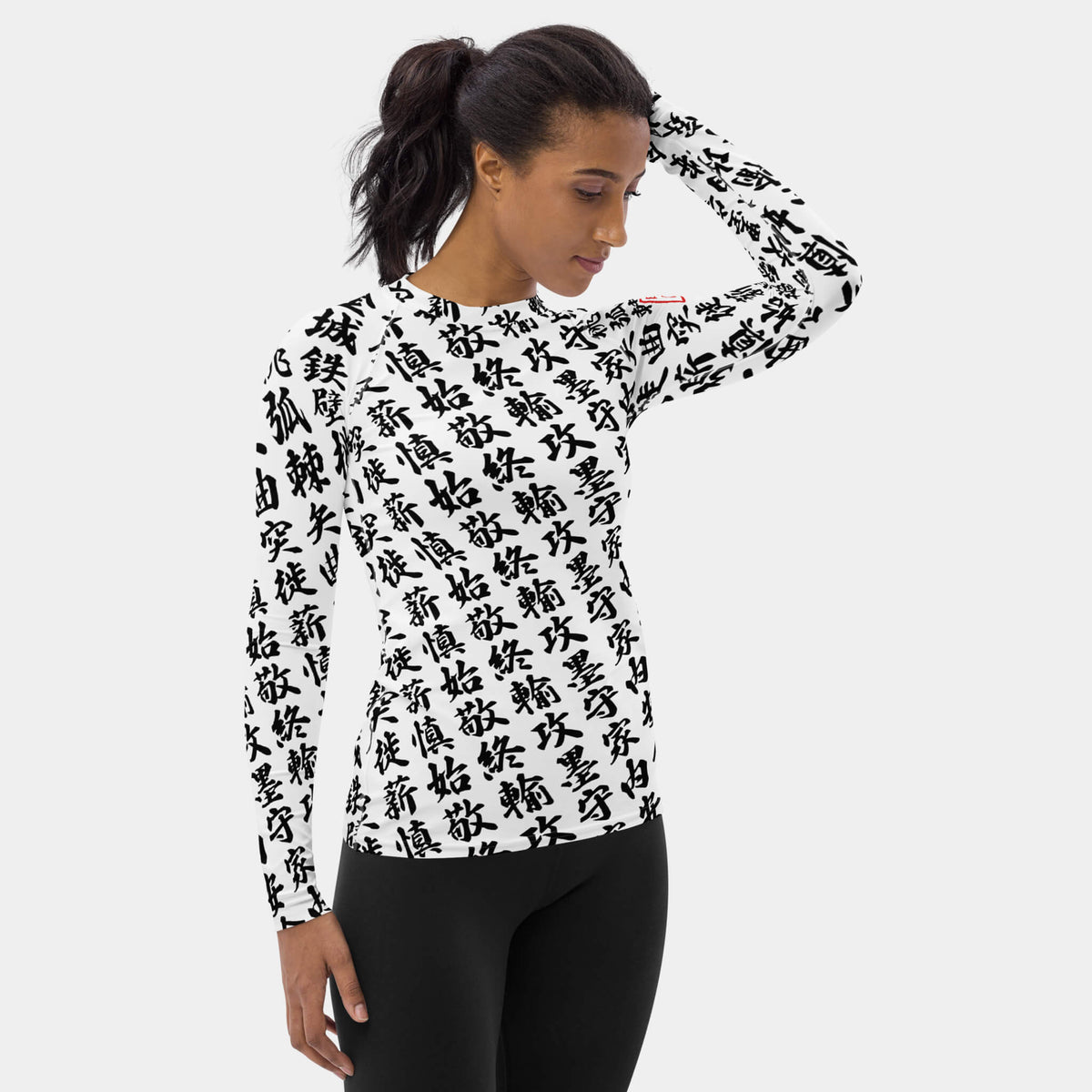 Right side view of the women's TOO MUCH KANJI long-sleeve BJJ rash guard in White and Black on a model, showing the all-over white kanji print